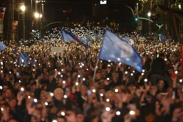 Protesters raise their mobile phones flashlights during an anti-government rally in Tirana, Albania, on Saturday, November 12, 2022. Thousands of Albanian opposition supporters protested against the center-left government's alleged corruption and this year's significant rise of prices due to the cost-of-living crisis. (Photo by Franc Zhurda/AP Photo)