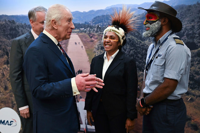 Britain's King Charles III with pilot Joseph Tua and Serah Michael MAF Flight operations supervisor during a visit to RAF Northolt in London, Thursday April 3, 2025, to celebrate the 80th anniversary of humanitarian air operator Mission Aviation Fellowship and unveil the charity's new Cessna 208 Caravan aircraft that will deliver aid to remote regions in Papua New Guinea. (Photo by Eddie Mulholland/Pool via AP Photo)