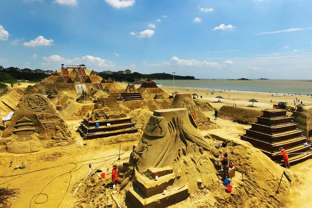 Artists work on sand sculptures for an event welcoming the G20 Summit in Zhoushan, Zhejiang Province, China, August 28, 2016. (Photo by Reuters/China Daily)