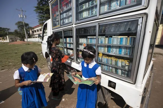 Rural children receive the books to read from a mobile library in Munshigonj, Bangladesh on November 7, 2022. The mobile library of Bishwo Shahitto Kendro or World Literature Center (WLC), running to facilitate the habit of reading improves access to books for children in rural areas in Bangladesh. (Photo by Abdul Goni/Anadolu Agency via Getty Images)