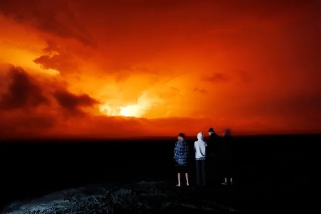 People watch the eruption of Mauna Loa, Monday, November 28, 2022, near Hilo, Hawaii. Mauna Loa, the world's largest active volcano erupted Monday for the first time in 38 years. (Photo by Marco Garcia)/AP Photo