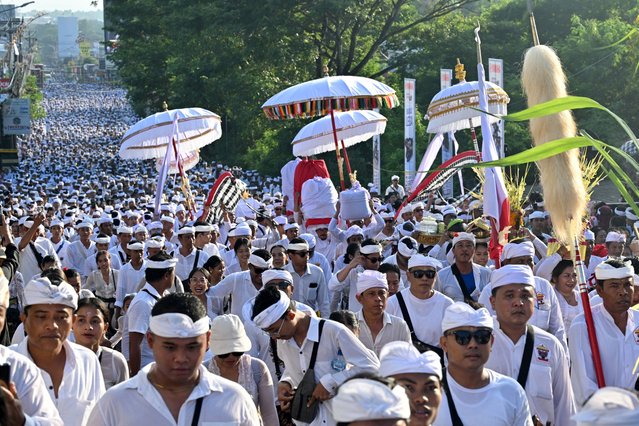 Members of the Jimbaran Indigenous community take part in a six kilometer procession from their villages to Uluwatu Temple as part of the Mepinton ceremony in Jimbaran, Indonesia's Bali island on May 11, 2025. (Photo by Sonny Tumbelaka/AFP Photo)