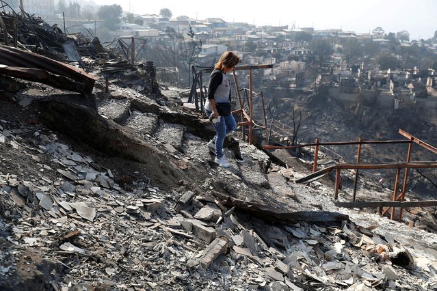 Ingrid Crespo walks on the remains of her house burned, following the spread of wildfires in Vina del Mar, Chile on February 5, 2024. (Photo by Rodrigo Garrido/Reuters)