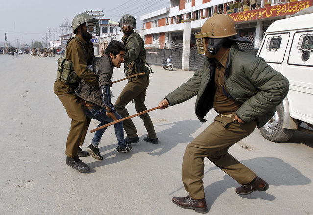 An Indian policeman wields his baton against a Kashmiri Shi'ite Muslim mourner  as he is detained during a Muharram procession in Srinagar, on November 1, 2014. (Photo by Danish Ismail/Reuters)