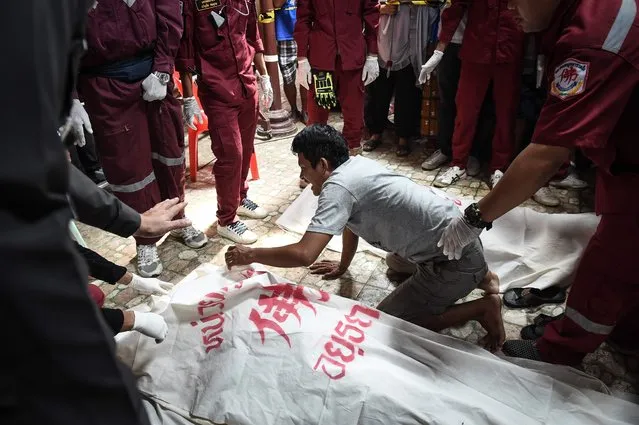 A man cries after the body of a female loved one is recovered from the Chao Praya river after a ferry capsized the day before in an accident, in the province of Ayutthaya on September 19, 2016. Divers resumed the search Monday for missing passengers after an overcrowded boat carrying Muslim pilgrims sank on Thailand's Chao Phraya river leaving at least 15 people dead, officials said. (Photo by Lillian Suwanrumpha/AFP Photo)