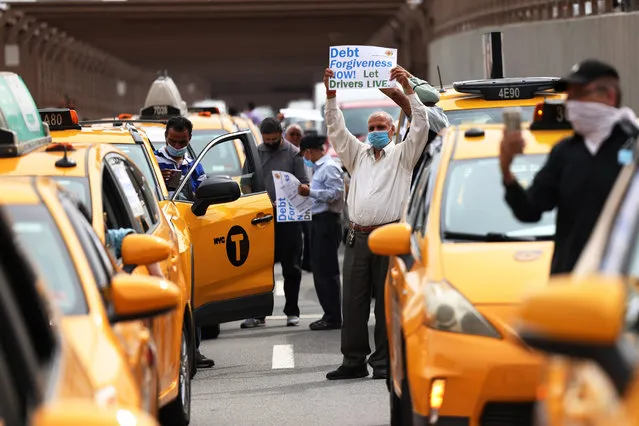 Taxi cab drivers hold signs as they stop traffic on the Brooklyn Bridge on September 17, 2020 in New York City. New York City taxi cab drivers held a day of action calling for debt forgiveness for loss of income amid work shortage due to the coronavirus (COVID-19) pandemic.  (Photo by Michael M. Santiago/Getty Images)