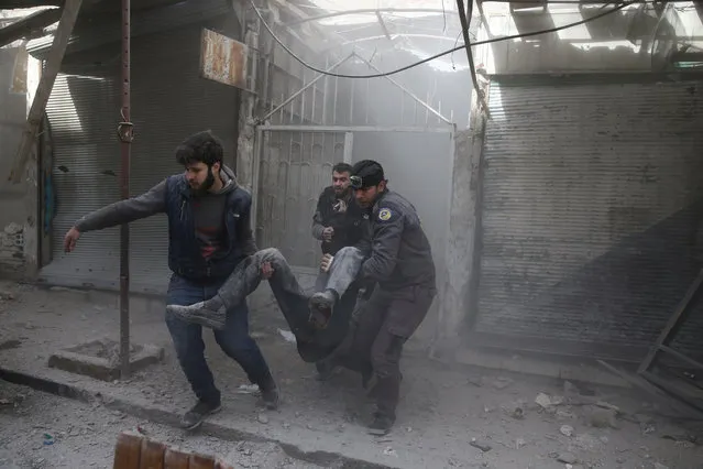 People hold an injured man after an airstrike in the besieged town of Douma in eastern Ghouta in Damascus, Syria, February 7, 2018. (Photo by Bassam Khabieh/Reuters)