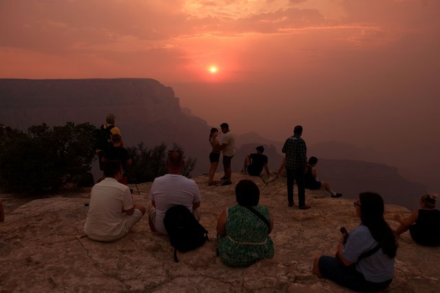 Smoke from the Dragon Bravo Fire colors a setting sun for onlookers at Grandeur Point on the southern rim of Grand Canyon, Arizona, U.S. July 14, 2025. (Photo by David Swanson/Reuters)