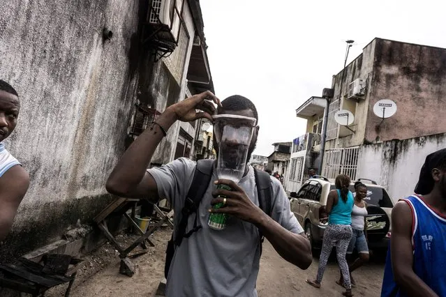 A Congolese man puts on an homemade gas mask during a protest called on by the Catholic Church, to push for the President of the Democratic Republic of the Congo, to step down on February 25, 2018 in Kinshasa. One person was killed and at least four injured as police fired live bullets and tear gas to disperse banned protests calling on DR Congo President Joseph Kabila to stand down. The church-backed protests in the Democratic Republic of Congo come after months of tension sparked by Kabila's prolonged rule and long-delayed elections in the vast and chronically unstable country. (Photo by John Wessels/AFP Photo)