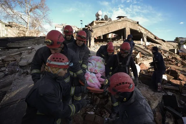 Rescue teams evacuate a survivor from the rubble of a destroyed building in Kahramanmaras, southern Turkey, Tuesday, February 7, 2023. A powerful earthquake hit southeast Turkey and Syria early Monday, toppling hundreds of buildings and killing and injuring thousands of people. (Photo by Khalil Hamra/AP Photo)
