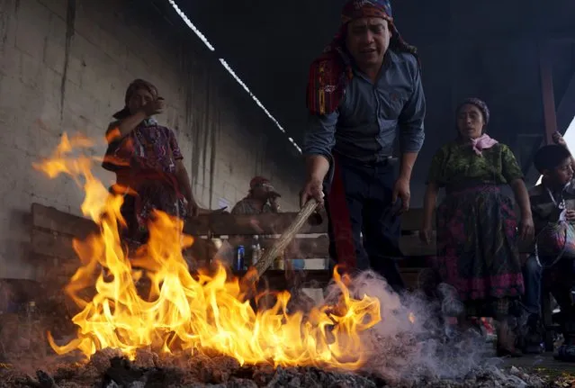 A mayan priest prepares a fire outside of San Simon church in Iztapa, in Chimaltenango, around 62 km (39 miles) from Guatemala City, October 28, 2015. (Photo by Jorge Dan Lopez/Reuters)