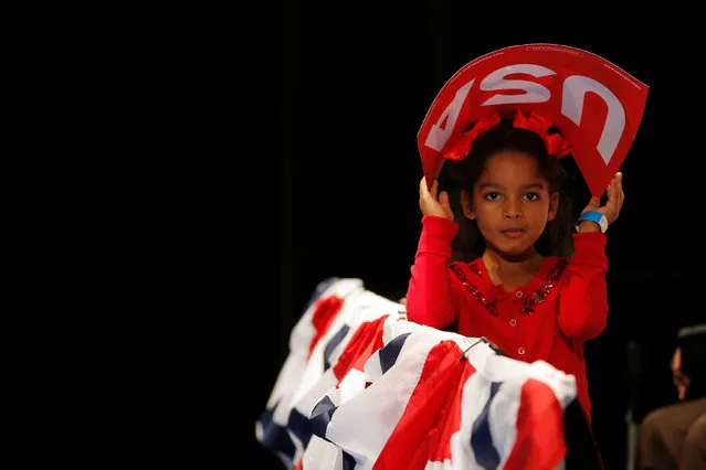 Six year-old Caylin Riggins holds a USA sign over her head before a campaign event with U.S. Democratic presidential candidate Hillary Clinton in Fort Pierce, Florida, U.S. September 30, 2016. (Photo by Brian Snyder/Reuters)