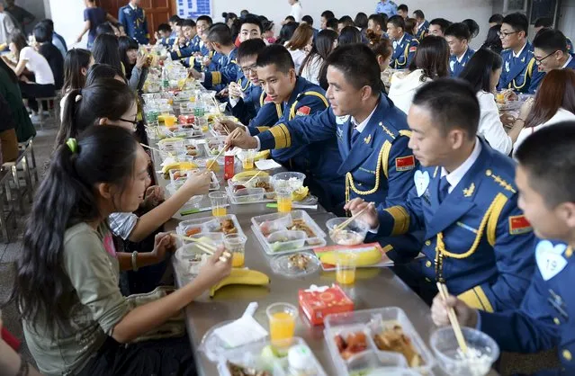 Soldiers of People's Liberation Army of China (PLC) Air Force talk to women as they have lunch together during a match-making event for military personnel, at a military base in Wuhan, Hubei province, China, October 17, 2015. Over 200 women participated in the event on Saturday, local media reported. (Photo by Reuters/China Daily)