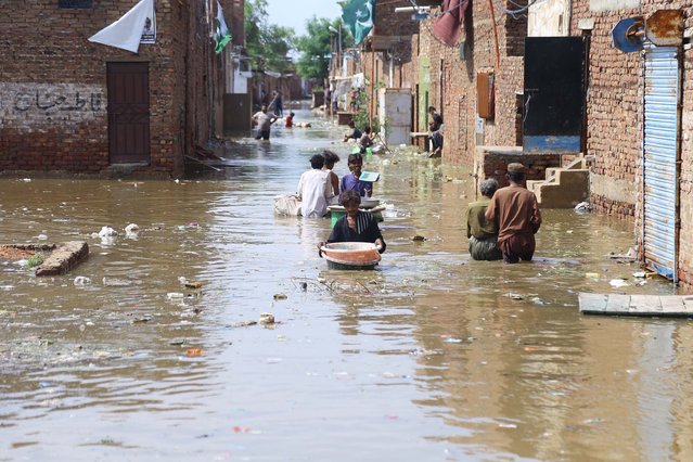 People wade through floodwater after heavy monsoon rains affected residencial areas in Hyderabad, Pakistan, 22 August 2025. According to the National Disaster Management Authority (NDMA), since the beginning of the monsoon season on 26 June the death toll from rains and flooding in Pakistan has reached at least 748 casualties, with 978 people injured. (Photo by Nadeem Khawer/EPA)