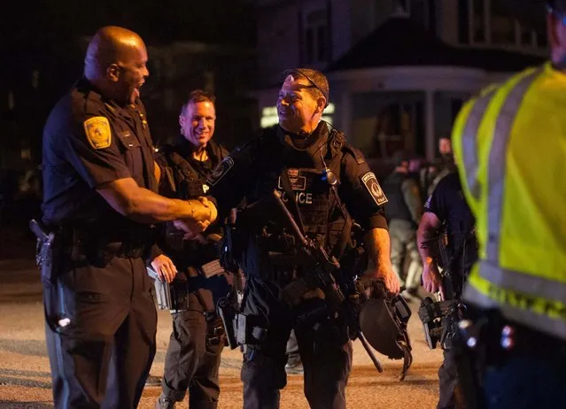 Police officers and SWAT team members greet each other after a police assault on a house on Franklin Street in Watertown, Massachusetts April 19, 2013. The manhunt for Dzhokhar Tsarnaev, 19, one of two brothers believed to have carried out the Boston Marathon bombing on Monday ended with his capture while hiding in the stern of a boat parked in the backyard of a house. (Photo by John Taggart/Reuters)