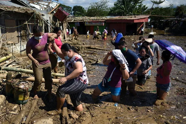 Residents wade through a flooded community as they attempt to return to their houses still submerged by flood following Typhoon Vamco, in Rodriguez, Rizal province, Philippines, November 13, 2020. (Photo by Lisa Marie David/Reuters)
