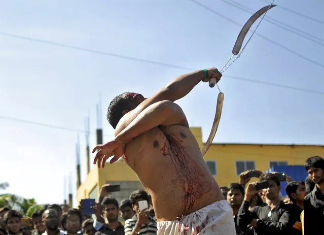 A Shi'ite Muslim flagellates himself during a Muharram procession to mark Ashura in Bengaluru, India, October 24, 2015. Ashura, which falls on the 10th day of the Islamic month of Muharram, commemorates the death of Imam Hussein, grandson of Prophet Mohammad, who was killed in the seventh century battle of Kerbala. (Photo by Abhishek N. Chinnappa/Reuters)