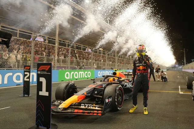 Red Bull driver Sergio Perez of Mexico stand next to his car after he won the Saudi Arabia Formula One Grand Prix at the Jeddah corniche circuit in Jeddah, Saudi Arabia, Sunday, March 19, 2023. (Photo by Luca Bruno/Pool via AP Photo)