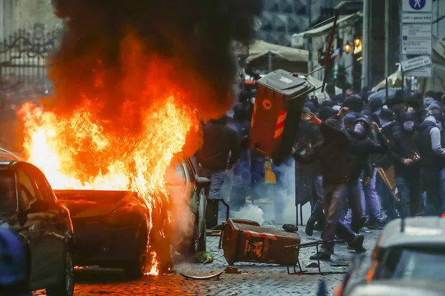 Supporters of the Eitracht Frankfurt soccer team clash with police in Naples, southern Italy, Wednesday, March 15, 2023, where their team is about to play a Champions League, round of 16, second leg soccer match against Naples. (Phoot by Salvatore Laporta/AP Photo)