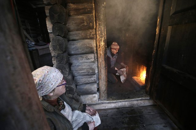 Eda Veeroja looks on as her husband Urmas Veeroja heats up their smoke sauna at Mooska farm, near the village of Haanja December 20, 2014. (Photo by Ints Kalnins/Reuters)