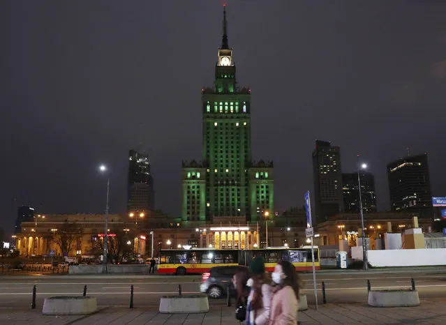 The iconic Palace of Culture in the Polish capital Warsaw, Poland, Saturday, December 12, 2020, is lit green to mark the 5th anniversary of the Paris climate accord. (Photo by Czarek Sokolowski/AP Photo)