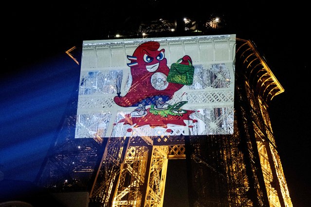 This photograph shows a projected image on the Eiffel Tower, depicting the Paris 2024 Olympic Games mascot Phryges during an action against “the cruel practices of LVMH, principal partner of the Paris 2024 Olympic Games” by the NGO People for the Ethical Treatment of Animals (PETA), in Paris on June 24, 2024. (Photo by Stefano Rellandini/AFP Photo)