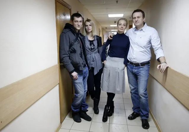 Russian opposition activist and anti-corruption crusader Alexei Navalny, 38, right, his wife Yulia, second right, and his brother Oleg Navalny, left, with his wife, pose for journalists  at a court in Moscow, Russia, Tuesday, December 30, 2014. The Moscow court on Monday moved up the date of its verdict in a criminal case against President Vladimir Putin's top foe Navalny in an apparent bid to derail a planned protest. (Photo by Pavel Golovkin/AP Photo)