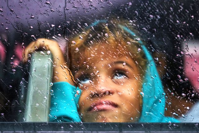 A girl looks out the bus window as she is evacuated before the arrival of Hurricane Melissa in Canizo, a community in Santiago de Cuba, Tuesday, October 28, 2025. (Photo by Ramón Espinosa/AP Photo)