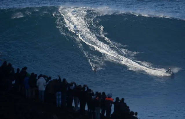 A surfer rides a wave off Praia do Norte (North Beach) near Nazare, central Portugal on October 24, 2016. (Photo by Francisco Leong/AFP Photo)