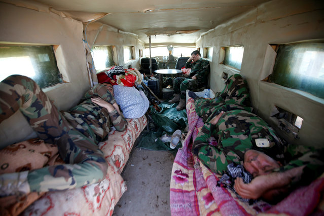 Peshmerga forces sleep at a military vehicle on the outskirt of Bashiqa east of Mosul, during the operation to attack Islamic State militants in Mosul, Iraq, October 30, 2016. (Photo by Azad Lashkari/Reuters)