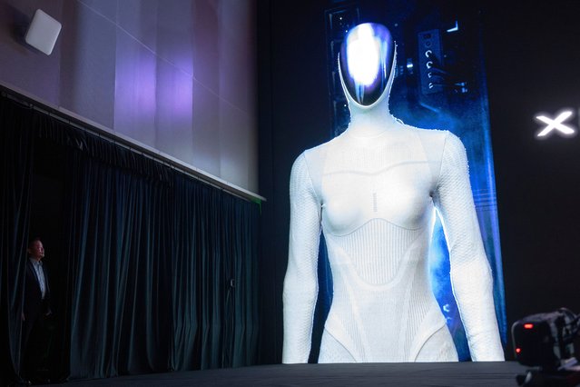 He Xiaopeng, Chairman and CEO of XPENG looks from behind a curtain as the image of the company's next generation IRON robot is seen on screen during the XPENG AI Day in Guangzhou in southern China's Guangdong province, Wednesday, November 5, 2025. (Photo by Ng Han Guan/AP Photo)