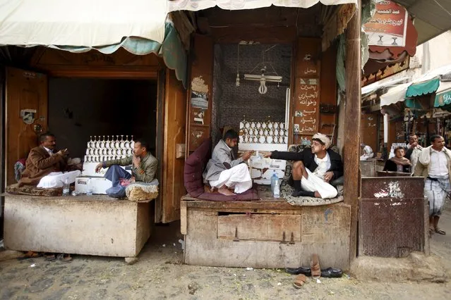 Vendors selling daggers chew qat, a mild stimulant, as they sit at their stalls in the old quarter of Yemen's capital Sanaa November 27, 2015. (Photo by Khaled Abdullah/Reuters)