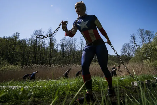 Competitors cross the Heavy Pull obstacle during the Tough Viking race on May 12, 2018 in Stockholm, Sweden. The course of the Tough Viking race consists of 8 kilometers filled with 26 brutal obstacles (barbed wire, mud, ice, water, tunnels, electricity, fire, climbing, etc.) designed by Swedish Armed Forces's specialists. (Photo by Jonathan Nackstrand/AFP Photo)