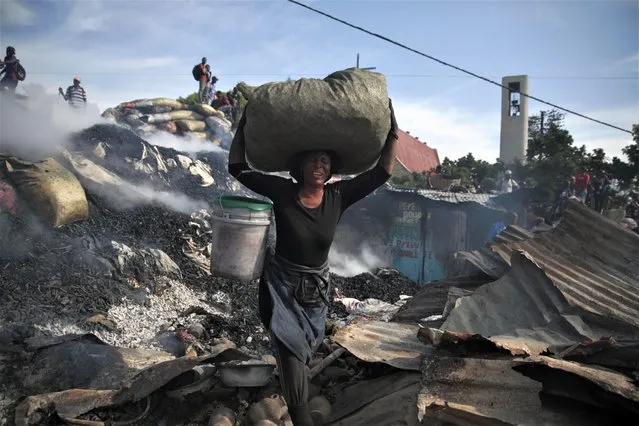 A vendor salvages items from the burned ruins of the Shada Market in the Petion-ville area of Port-au-Prince, Haiti, Thursday, May 4, 2023. (Photo by Joseph Odelyn/AP Photo)