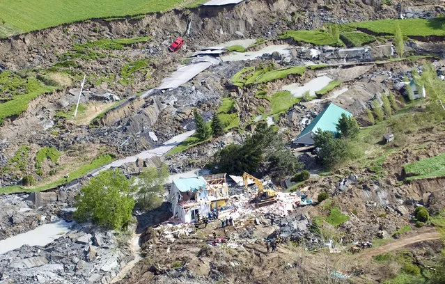 Rescuers work at the scene of a landslide in Saint-Jude, Quebec as shown from the air on Tuesday, May 11, 2010. Four people, including two children, are missing after a sinkhole triggered by a landslide swallowed their house northeast of Montreal. (Photo by Graham Hughes/AP Photo/The Canadian Press via The Atlantic)