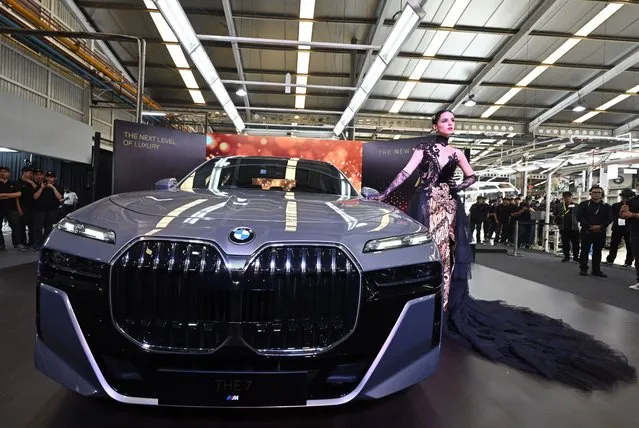 In this picture taken in Jakarta on June 6, 2023 a model stands next to the new 7 series BMW car during the launching and a plant tour in Jakarta. (Photo by Adek Berry/AFP Photo)