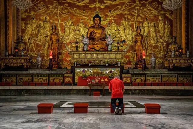 A man prays alone inside a nearly empty Seng Guan temple, usually crowded during Lunar New Year celebrations, on February 12, 2021 in Manila, Philippines. The Chinese diaspora of Southeast Asia is celebrating a somewhat subdued Lunar New Year as COVID-19 restrictions cut into what is traditionally a time for people to meet their relatives and take part in celebrations with extended families. (Photo by Ezra Acayan/Getty Images)