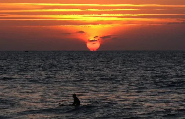 A Palestinian youth takes a rest while surfing at a beach in Gaza City, Gaza Strip, 19 October 2016. (Photo by Mohammed Saber/EPA)