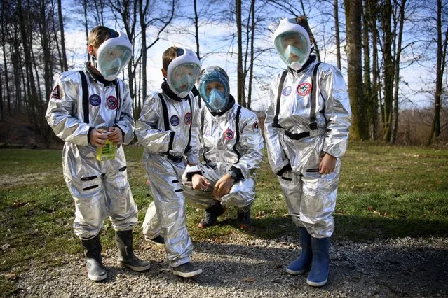 8 year old students of the private school Vivalys dressed as astronauts experiment the germination of a seed with their teacher as they conduct a three days simulation of life in a space base on the planet Mars during the coronavirus disease (COVID-19) outbreak, in Lausanne, Switzerland, 18 March 2021. The students underwent specific training to acquire new knowledge in mathematics, physics, botany and social sciences. (Photo by Laurent Gillieron/EPA/EFE)