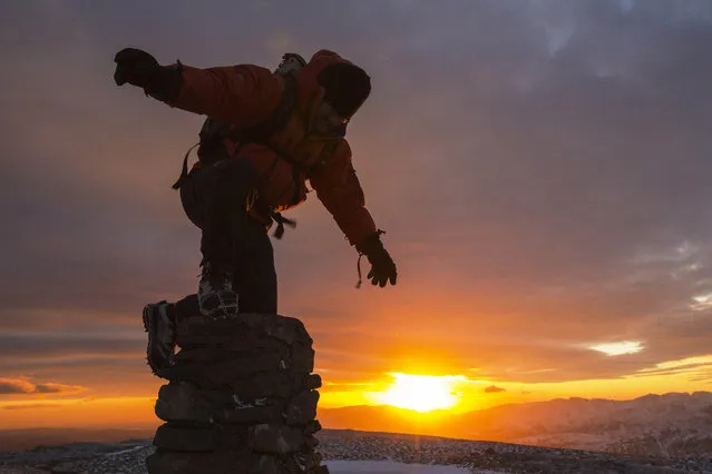 A walker on the summit of Red Screes at sunset on February 04, 2015 in Lake District, England. (Photo by Ashley Cooper/Barcroft Media)