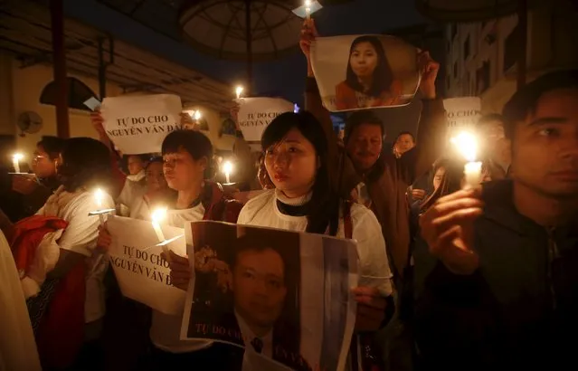 Vu Minh Khanh (C) holds image of her husband Nguyen Van Dai as Catholics hold candles and images of Dai's assistant Le Thu Ha during a mass prayer for Dai and Ha at Thai Ha church in Hanoi, December 27, 2015. Rights activist Nguyen Van Dai, who was badly beaten this month by unknown attackers, was arrested last week for anti-state “propaganda”, the latest incident in what rights groups are calling an alarming crackdown on government critics. (Photo by Reuters/Kham)