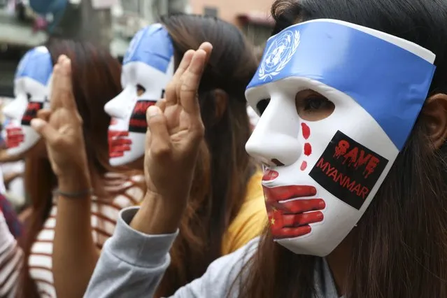 Young demonstrators flash the three-fingered symbol of resistance during an anti-coup mask strike in Yangon, Myanmar, Sunday, April 4, 2021. Threats of lethal violence and arrests of protesters have failed to suppress daily demonstrations across Myanmar demanding the military step down and reinstate the democratically elected government. (Photo by AP Photo/Stringer)