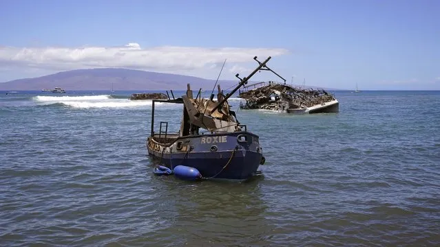 Burnt boats sit in waters off of Lahaina, Hawaii, on Friday, August 11, 2023. The search of the wildfire wreckage on the Hawaiian island of Maui revealed a wasteland of burned out homes and obliterated communities. (Photo by Rick Bowmer/AP Photo)