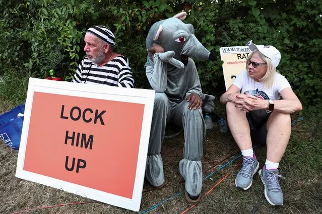 Anti-Trump demonstrators rest near the entrance of the Fulton County Jail, as former U.S. President Donald Trump is expected to turn himself in to be processed after his Georgia indictment, in Atlanta, Georgia, U.S., August 24, 2023. (Photo by Dustin Chambers/Reuters)