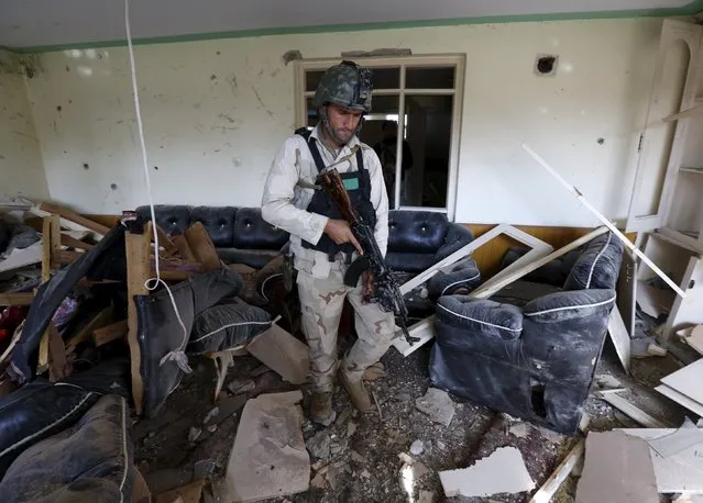 A member of the Afghan security force inspects a damaged building after a blast near the Pakistani consulate in Jalalabad, Afghanistan January 13, 2016. (Photo by Reuters/Parwiz)