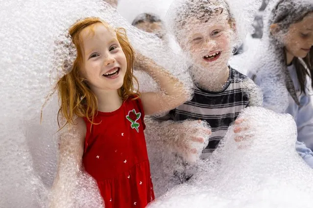 Children play among foaming bubbles that form an artwork by Roger Hiorns entitled A Retrospective View of the Pathway, at the Yorkshire Sculpture Park near Wakefield, UK on August 16, 2023. (Photo by James Glossop/The Times)