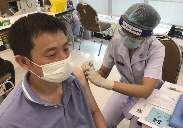 A health worker administers a dose of the Sinovac COVID-19 vaccine to Zhang Xiaohong, a 40-year-old businessman who runs a logistic company in Thailand, at Bangrak Vaccination and Health Center in Bangkok, Thailand Thursday, May 20, 2021. China began vaccinating its citizens living in Thailand on Thursday as part of a global campaign to inoculate its nationals living and working abroad. (Photo by Fu Ting/AP Photo)