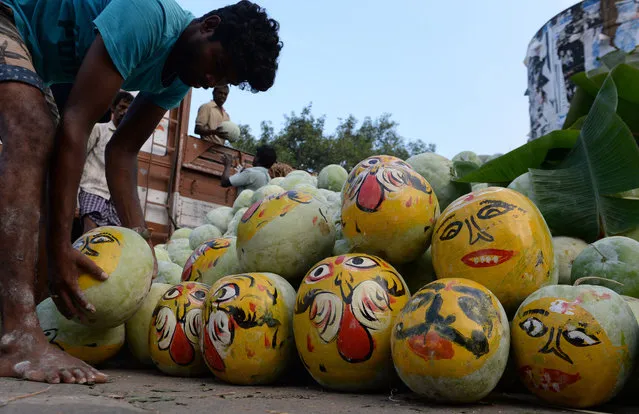Indian vendors organise pumpkins painted to resemble demons during the Durga Puja festival at a wholesale flower market in Chennai on October 16, 2018. The five- day Durga Puja festival, which commemorates the slaying of the demon king Mahishasur by the goddess Durga, marks the triumph of good over evil. (Photo by Arun Sankar/AFP Photo)