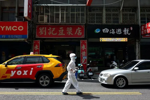 A person dressed in protective suit walks down a street following the recent surge of coronavirus disease (COVID-19) infections in Taipei, Taiwan, June 2, 2021. (Photo by Ann Wang/Reuters)