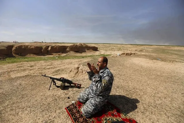 A member of the Iraqi security forces prays in the town of Tal Ksaiba, near the town of al-Alam March 7, 2015. (Photo by Thaier Al-Sudani/Reuters)